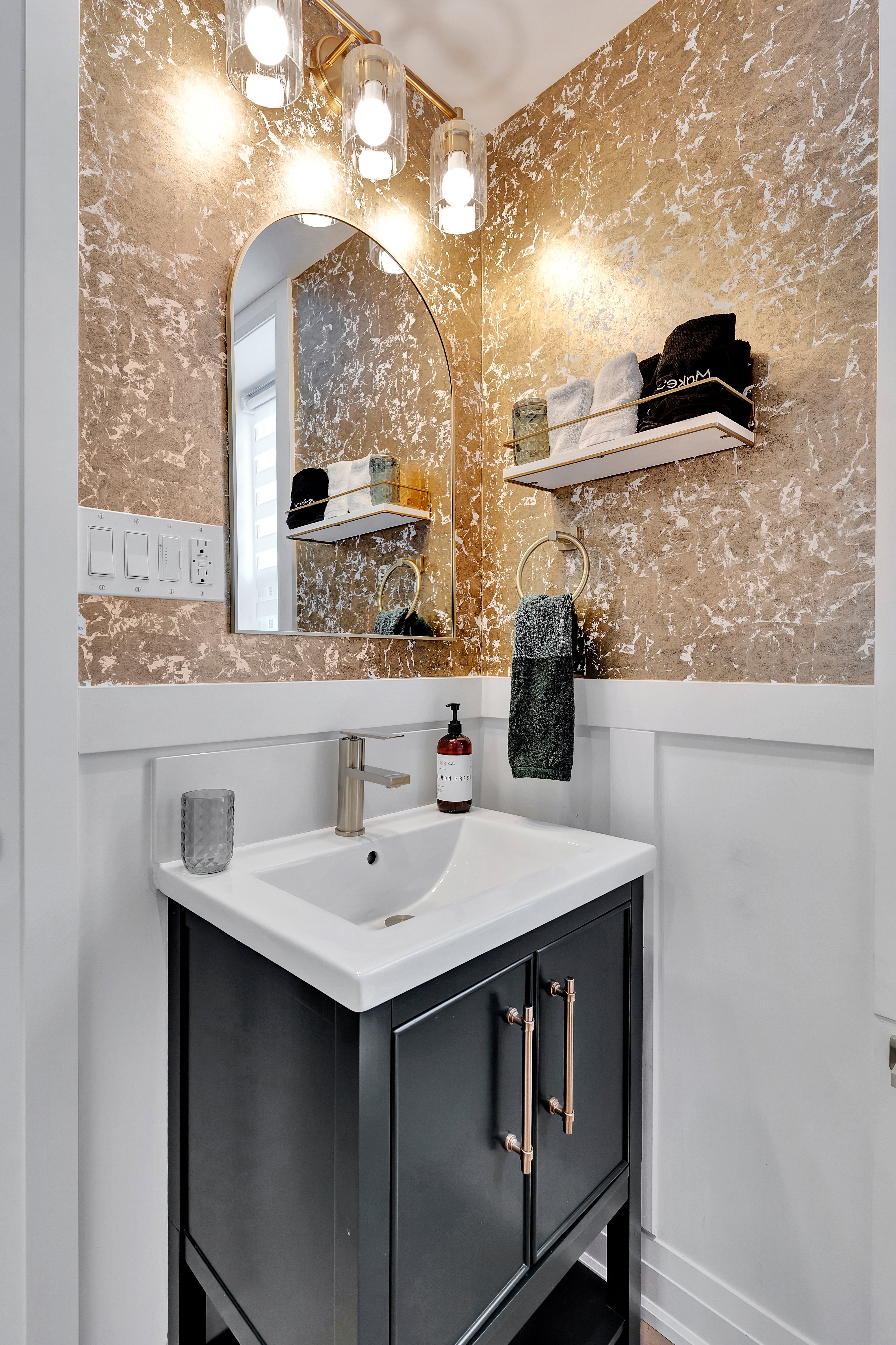 Gold marble bathroom with brass fixtures