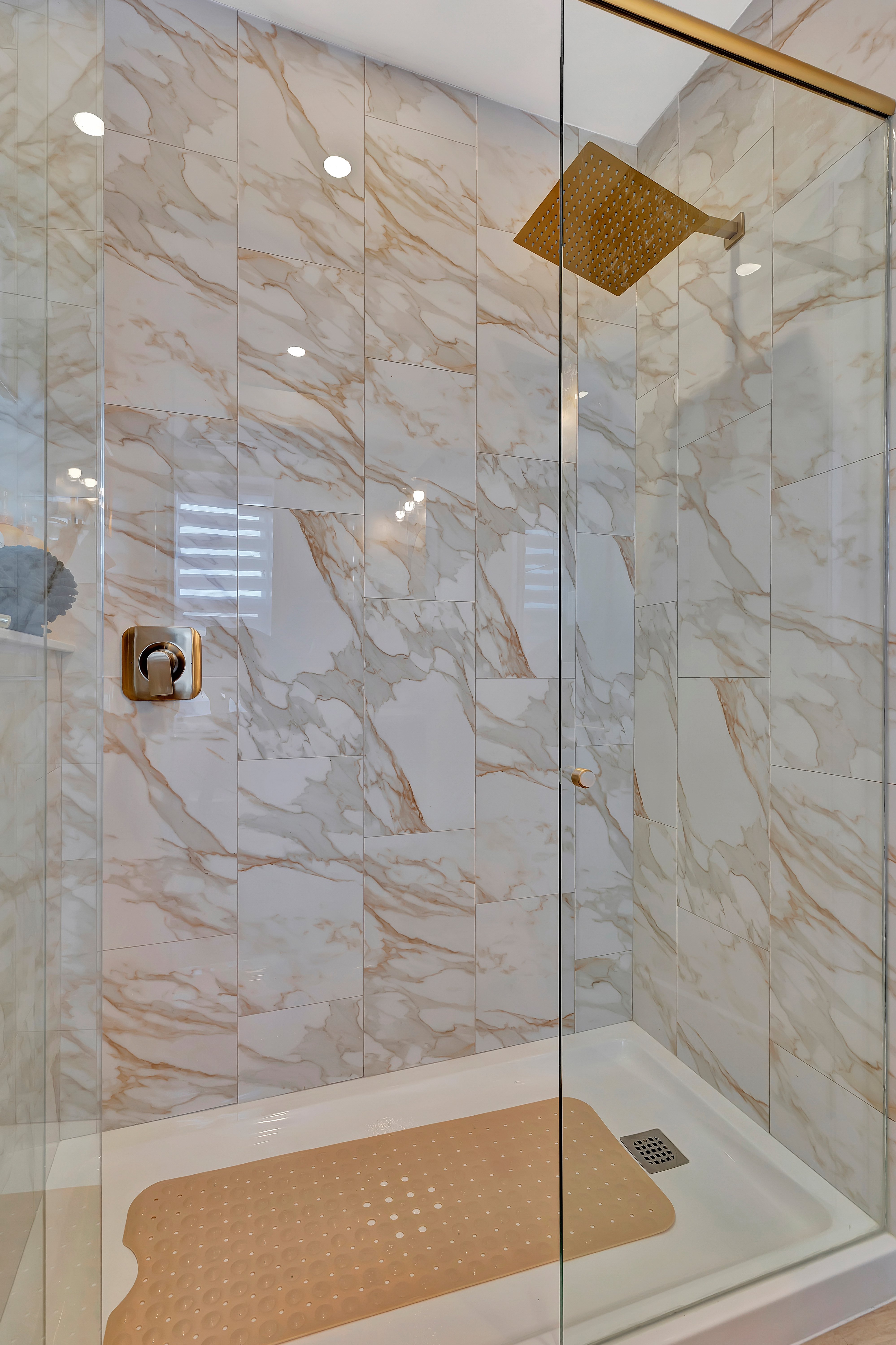 Marble rainfall shower with gold fixtures